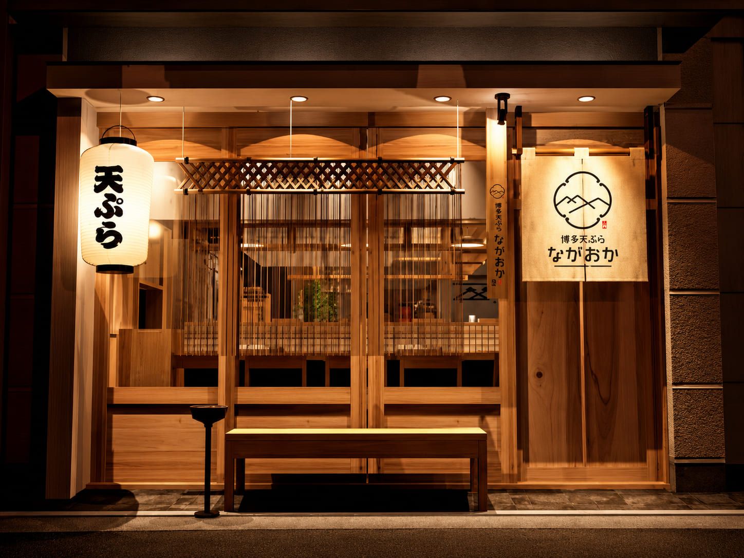 提灯とのれんに灯りがともる、夜の博多天ぷら ながおか本店の外観
