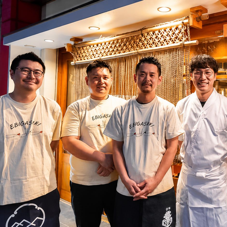 店先に並んで笑顔を見せる、博多天ぷら ながおか本店のスタッフ4人